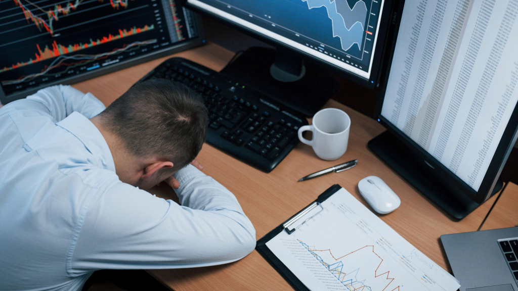 In stress because unexpected fail. Man working online in the office with multiple computer screens in index charts