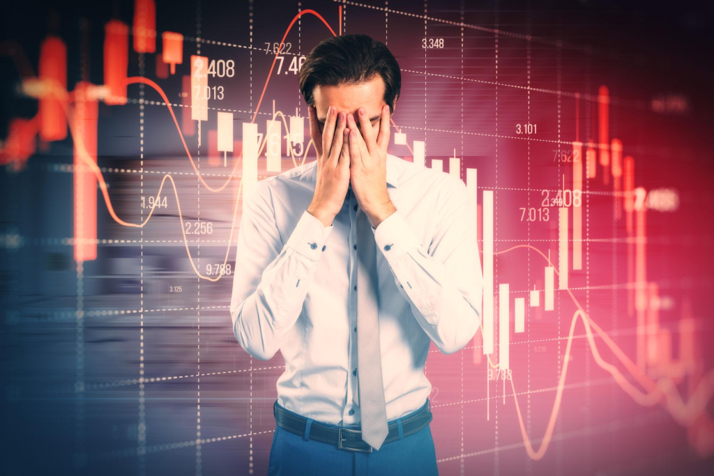 Stressed out businessman with falling red forex candlestick chart on blurry background. Global economic recession, stock market crash, inflation concept. in Forex Jireenya Jijjiiruu